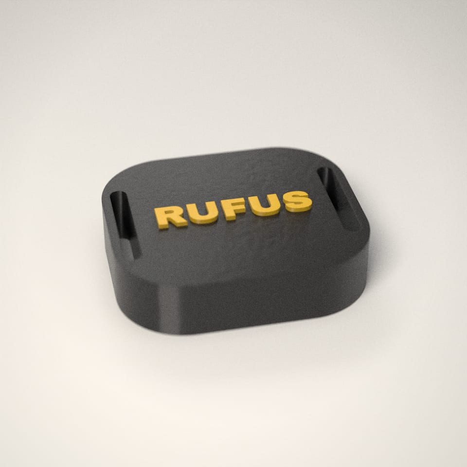 Jet Black personalised AirTag Holder for Dog Collars reading 'RUFUS' in Sunflower letters