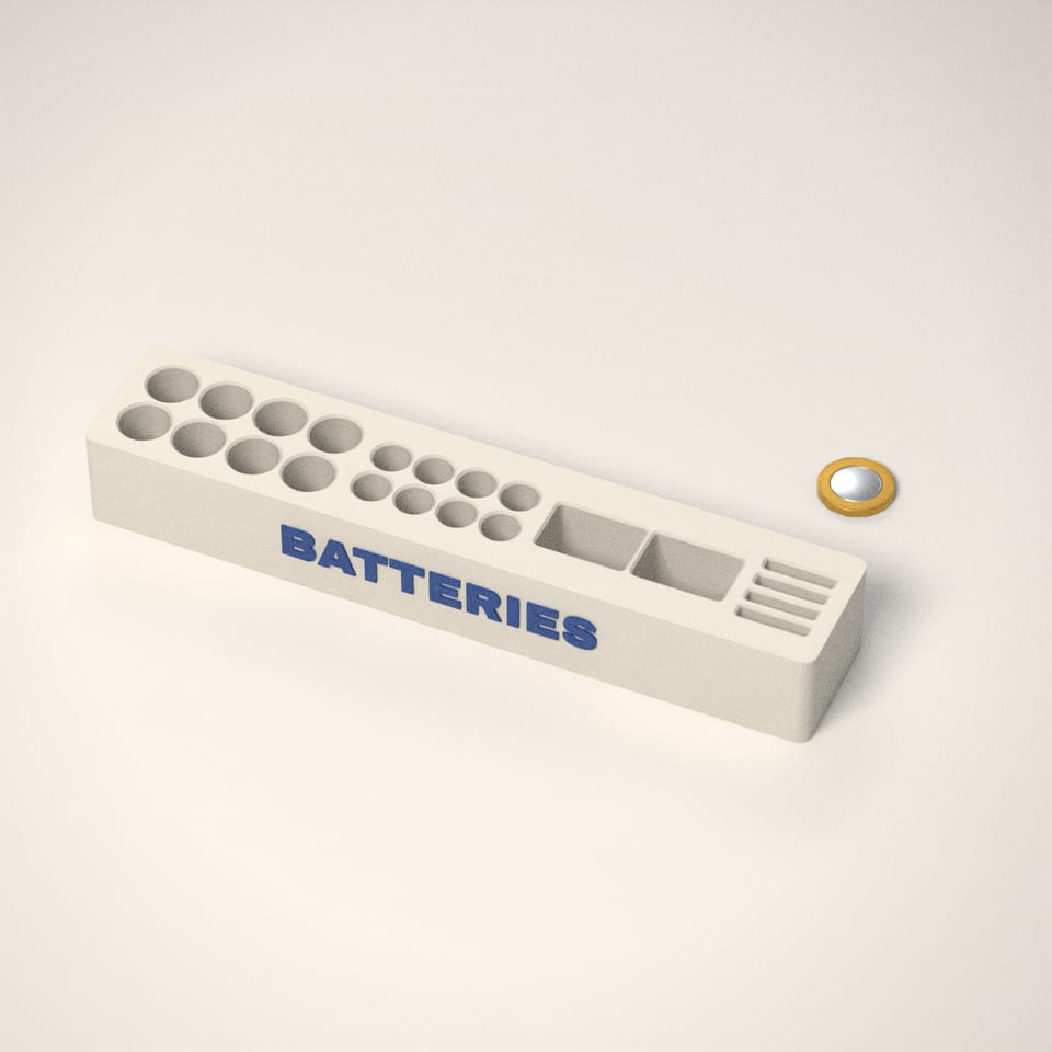 Battery Organiser next to a £1-coin-sized disc for scale
