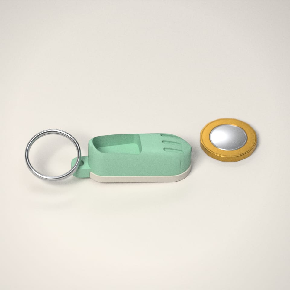 Mini Clog Keychain next to a £1-coin-sized disc for scale