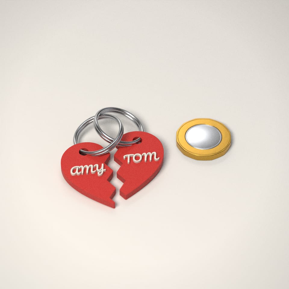 Couples Heart Keyrings (Set of 2) next to a £1-coin-sized disc for scale