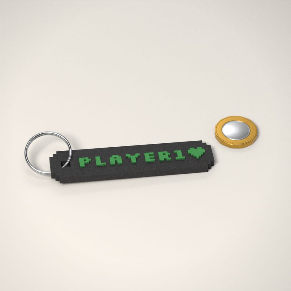 Pixel Name Keyring next to a £1-coin-sized disc for scale